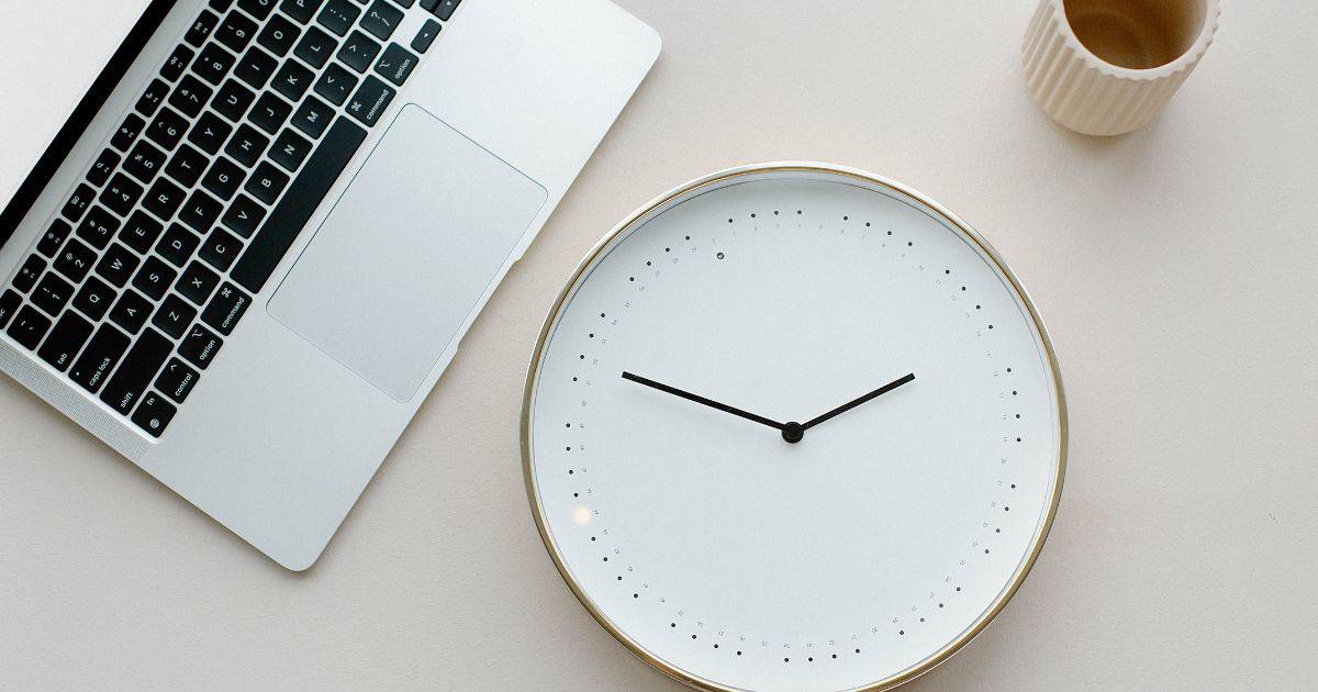 Laptop and clock on desk. how long does it take for a website to show in google